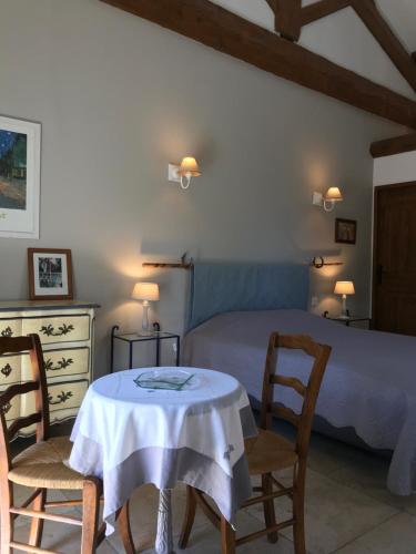 - une chambre avec un lit, une table et des chaises dans l'établissement Mas d'Auzières, à Saint-Gilles
