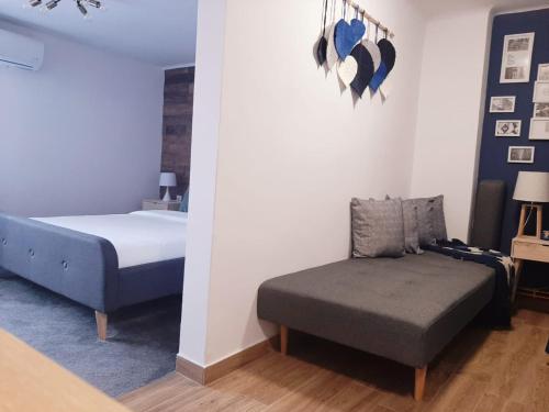 a bedroom with a bed and a couch and a chair at Bulevard mansards in Satu Mare
