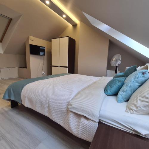 a bedroom with a large white bed with blue pillows at Apartament Blue Bay Jantar in Jantar