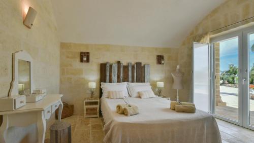 a bedroom with a large bed with towels on it at Villa Merlata in Ostuni