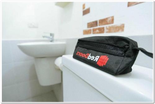 a black bag sitting on top of a counter in a bathroom at RedDoorz @ Sindangbarang Bogor in Bogor