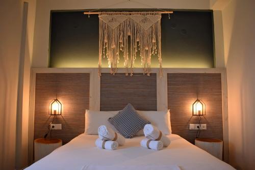 a bedroom with a white bed with towels on it at Pasithea in Frangokastello