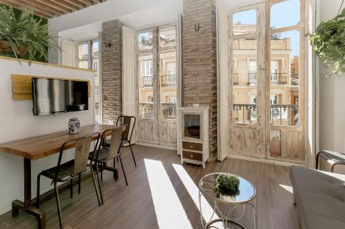 ein Wohnzimmer mit einem Esstisch und einem Kamin in der Unterkunft Urban Hipster 2 in Málaga