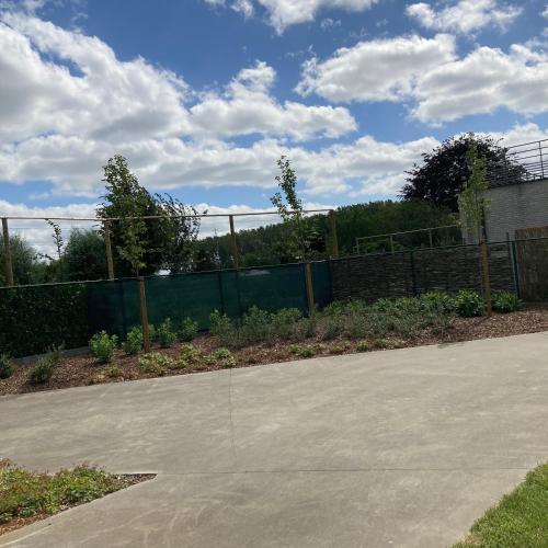 a concrete driveway with a fence in the background at Holiday home De Levensgenieter in Torhout