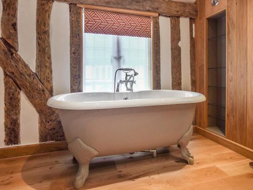 a white bath tub in a room with a window at Mercia House in Winchcombe