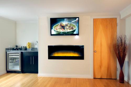 a kitchen with a fireplace with a picture on the wall at Bricco Suites in Boston