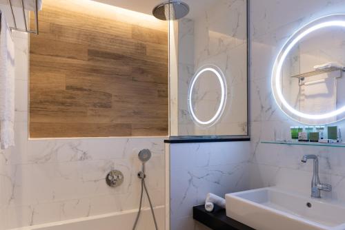 a bathroom with a tub and a sink and a mirror at Lord Byron in Paris