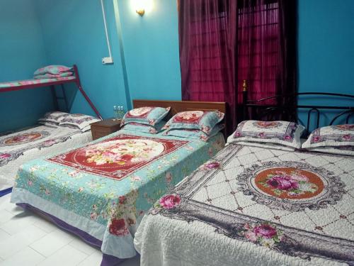 dwa łóżka w sypialni z niebieskimi ścianami w obiekcie Homestay Roomstay Muar Srizahrani w mieście Muar
