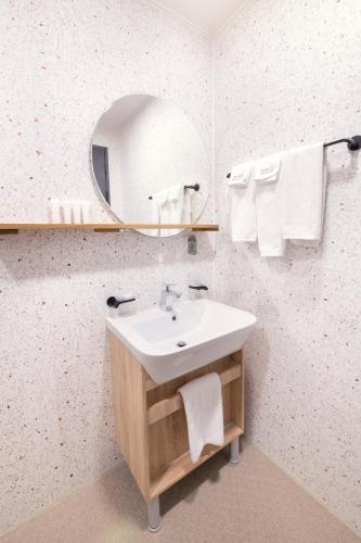 a bathroom with a sink and a mirror at Mipo Oceanside Hotel in Busan