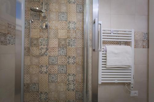 a bathroom with a shower with a towel at Via Siena 4 - Suites & Rooms in Marina di Cecina