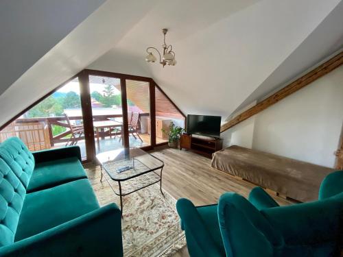 a room with a bed and chairs and a television at VILLA ANGEL in Rožňava