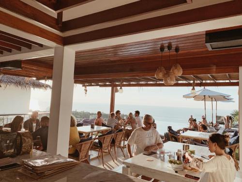 eine Gruppe von Menschen, die an Tischen in einem Restaurant sitzen in der Unterkunft High Life Villas in Salad Beach