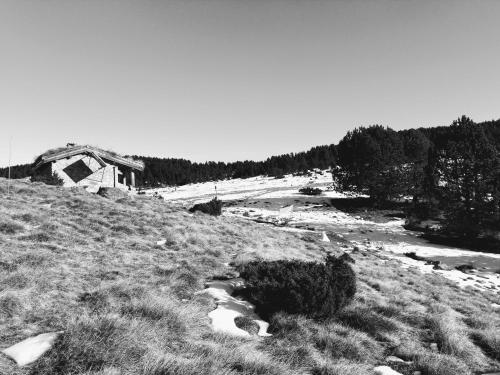 czarno-białe zdjęcie pola z domem w obiekcie STUDIOS MAGUI w mieście Ax-les-Thermes