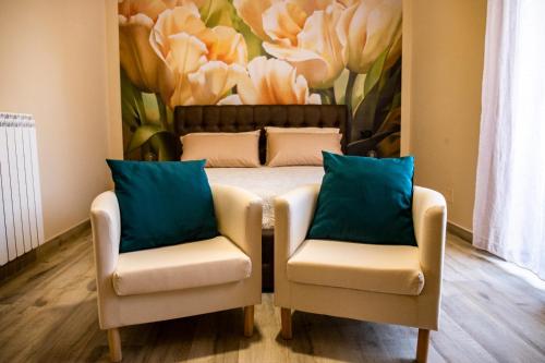 a bedroom with two chairs and a bed with a painting at DoSe di relax in Casertavecchia