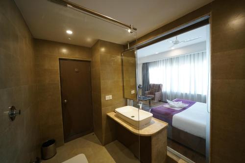 a bathroom with a bed and a sink and a shower at New Hotel Broadway in Varanasi