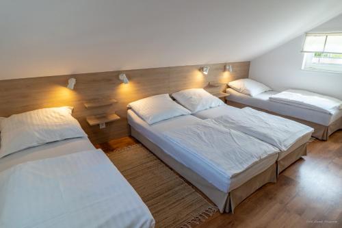 a bedroom with three beds in a room at Domki Letniskowe AlexJan in Dąbki