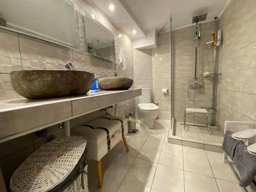 a bathroom with a sink and a shower and a toilet at Lemon Suite in Kavala