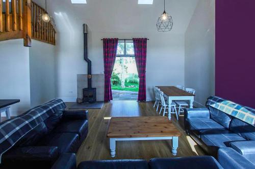 a living room with blue couches and a coffee table at Borthwick Castle View in North Middleton