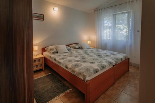 a bedroom with a large bed and a window at Apartmani Melem in Stari Grad