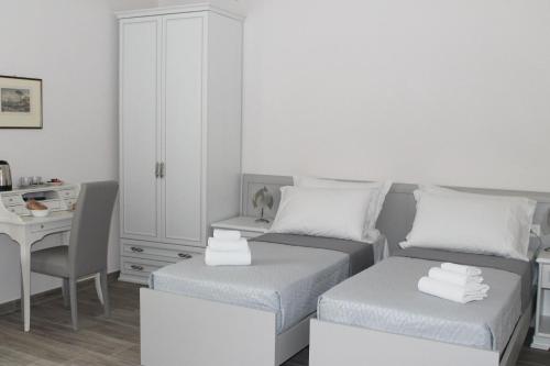 1 dormitorio con 2 camas, escritorio y armario en L'Acchiappasogni Vesuviano Guest House en Portici