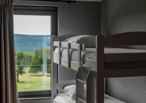 a bedroom with two bunk beds and a window at XXV House - 12 personnes in Héron