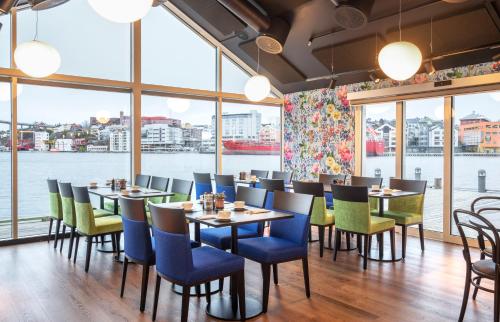 a restaurant with tables and chairs and a large window at Thon Hotel Kristiansund in Kristiansund