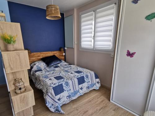 - une chambre avec un lit et un mur bleu dans l'établissement Envolée Marine pour 3 pers - Berck-Plage - 250m plage et commerces, à Berck-sur-Mer