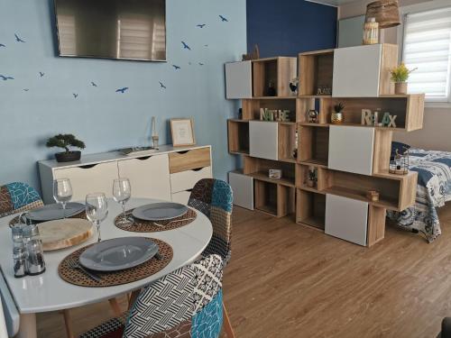 comedor con mesa, sillas y estante para libros en Envolée Marine pour 3 pers - Berck-Plage - 250m plage et commerces, en Berck-sur-Mer