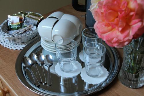 a tray with glasses and plates and spoons on a table at Blankenfeldes muiža in Tērvete