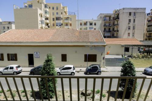 a group of cars parked in a parking lot with buildings at FG Vacanze in Alghero