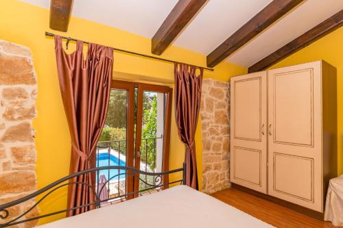 a bedroom with yellow walls and a bed and a window at Casa Ghedda in Gedići