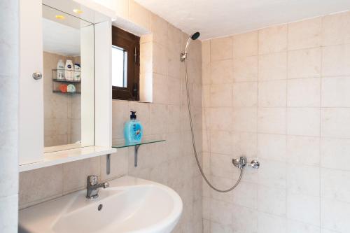bagno con lavandino e doccia con specchio di 1900's traditional house in Asklipio a Asklipiḯon