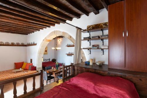 ein Schlafzimmer mit einem Bett und einem Tisch in einem Zimmer in der Unterkunft 1900's traditional house in Asklipio in Asklipiḯon