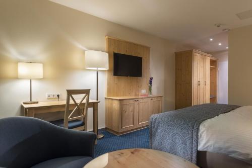 a hotel room with a bed and a desk at Maritim Titisee Hotel in Titisee-Neustadt