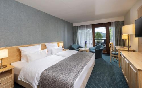 a hotel room with a bed and a desk at Maritim Titisee Hotel in Titisee-Neustadt