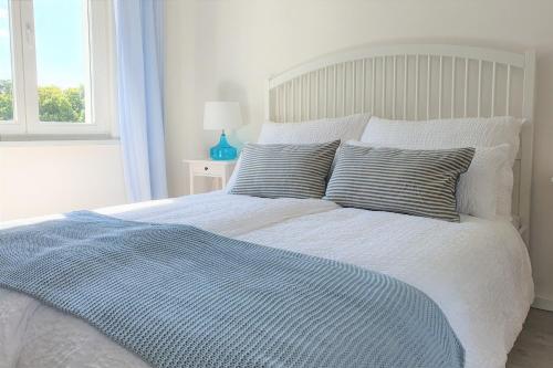 a bed with a blue and white blanket and pillows at PB Ferienwohnungen - FeWo 5 - Stilvoll eingerichtetes Studio im Herzen Senftenbergs in Senftenberg
