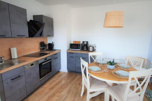 a kitchen with a table and chairs and a kitchen with a sink at PB Ferienwohnungen - FeWo 5 - Stilvoll eingerichtetes Studio im Herzen Senftenbergs in Senftenberg