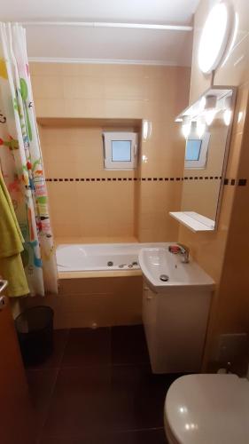 a bathroom with a tub and a toilet and a sink at Apartament Lara in Constanţa