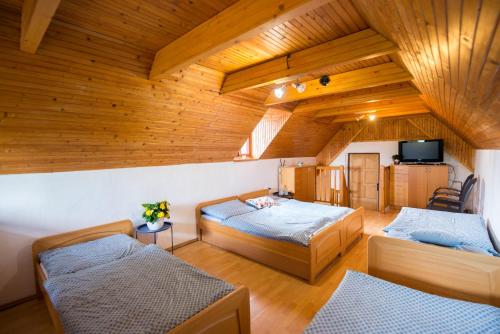 two beds in a room with wooden ceilings at Apartmán Albert v Spa dedinke in Zvolen