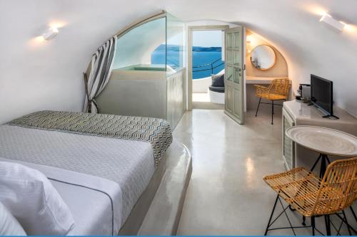 Postel nebo postele na pokoji v ubytování Kaleidoscope Oia Suites