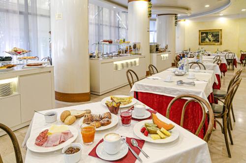 een eetkamer met tafels met borden eten bij Hotel Metropolitan in Bellaria-Igea Marina