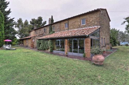 una gran casa de ladrillo con un gran patio en Agriturismo Antico Podere Il Polveraio, en Montescudaio