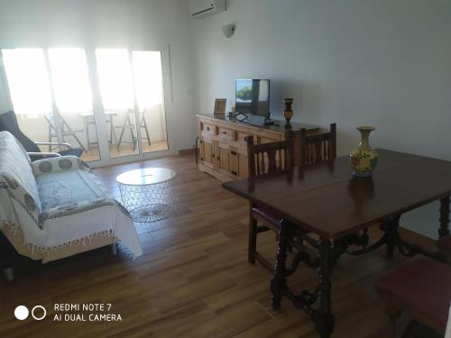 una sala de estar con una mesa y un sofá en BUNGALOW CHARO, en Torre de Benagalbón
