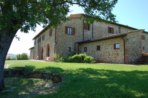 a large stone building with a tree in front of it at Locanda Vesuna Hotel Countryhouse in Pienza
