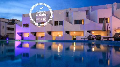 a view of a building with a pool at night at Lagoa Hotel in Lagoa
