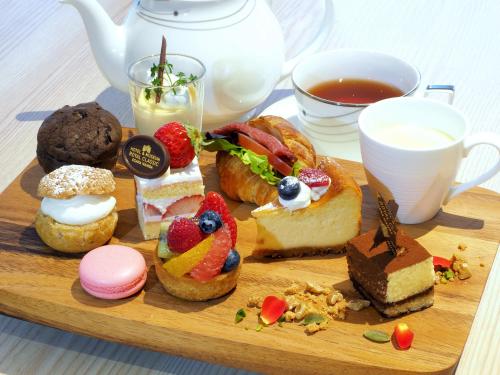 a wooden tray with pastries and a cup of tea at Hotel Royal Classic Osaka in Osaka