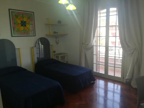 a bedroom with two beds and a window and a door at b&b le zagare in Caltanissetta