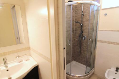 ein Bad mit einer Dusche und einem Waschbecken in der Unterkunft Casa al Teatro in Syrakus