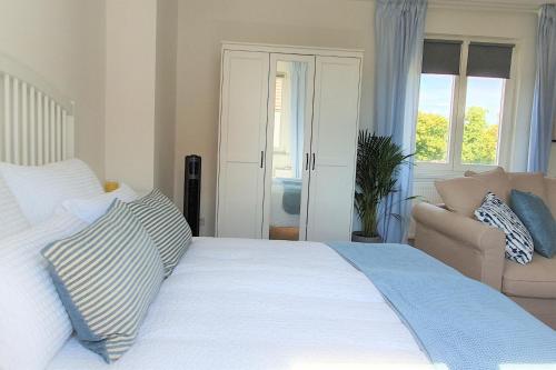 a bedroom with a large white bed and a couch at PB Ferienwohnungen - FeWo 5 - Stilvoll eingerichtetes Studio im Herzen Senftenbergs in Senftenberg