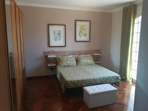 een slaapkamer met een bed en twee foto's aan de muur bij b&b le zagare in Caltanissetta